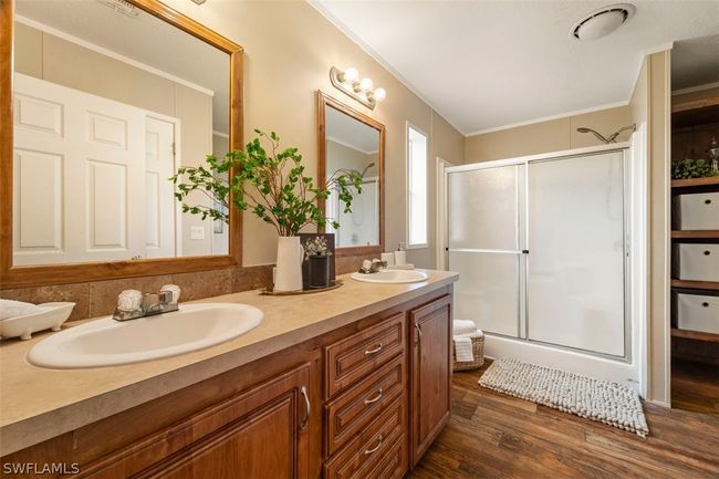 Bathroom featuring crown molding, an enclosed shower, dual vanity, and hardwood / wood-style floors | Image 14