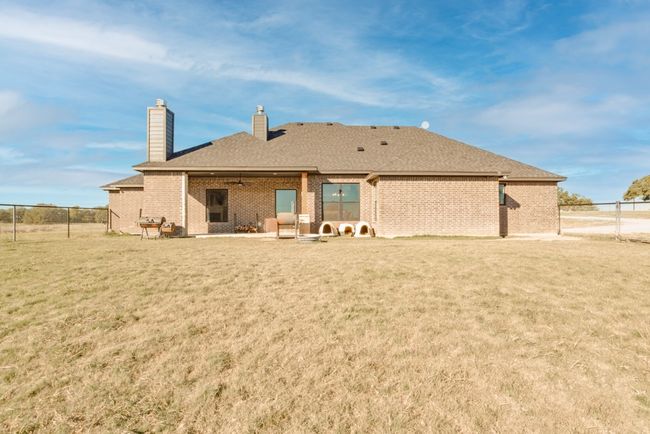 Rear view of property featuring a lawn, fence, a chimney, and brick siding | Image 29