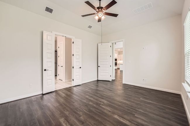 Unfurnished bedroom featuring dark wood-type flooring, baseboards, high vaulted ceiling, and a ceiling fan | Image 15