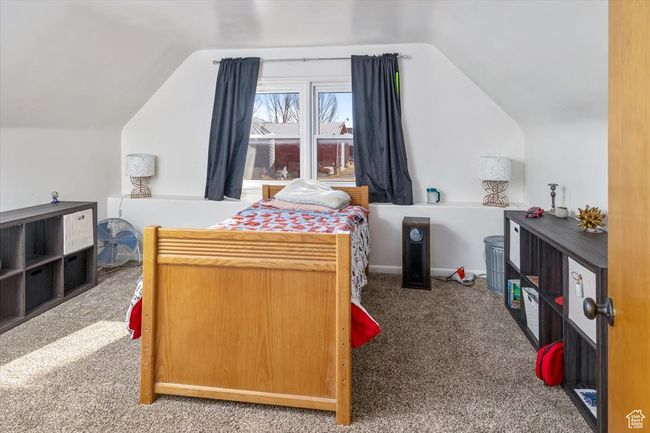 Bedroom with carpet flooring and lofted ceiling | Image 27