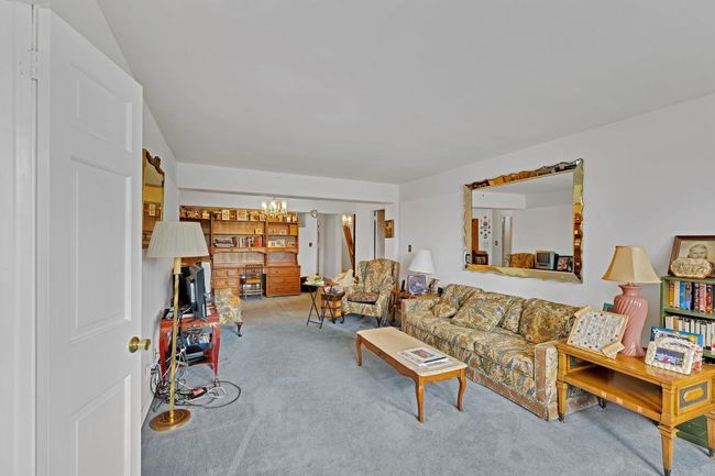 Living area with carpet flooring and a chandelier | Image 15