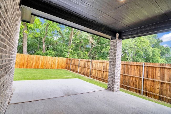Fenced backyard with a patio area | Image 24