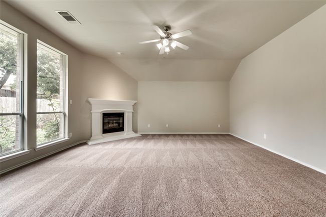 Unfurnished living room with ceiling fan, carpet, lofted ceiling, and a glass covered fireplace | Image 17