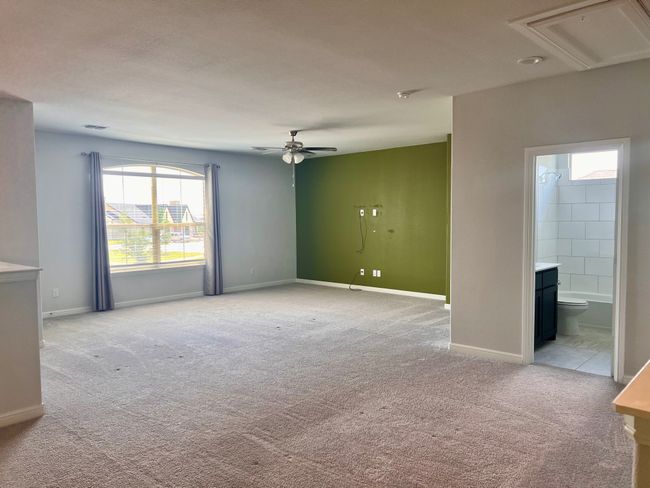 Unfurnished room with light colored carpet, healthy amount of natural light, a ceiling fan, and attic access | Image 16