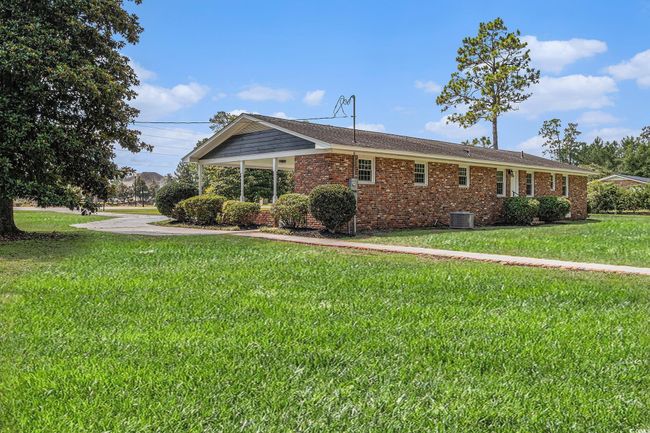 View of property exterior featuring brick and a very rare large yard located within the City of Conway. | Image 6