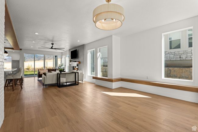 Living area featuring light wood-type flooring, a ceiling fan, and recessed lighting | Image 10