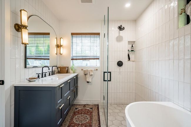 Full bathroom featuring a soaking tub, vanity, a stall shower, and tile patterned flooring | Image 15
