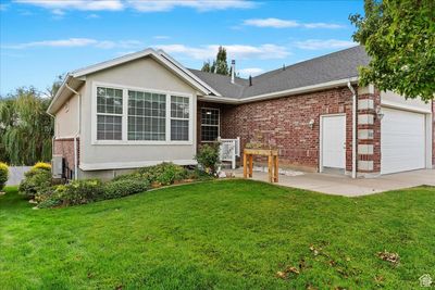 Ranch-style house with a front yard and a garage | Image 1