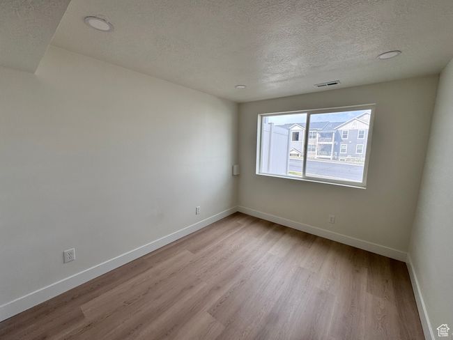 Spare room featuring wood finished floors, visible vents, baseboards, and a textured ceiling | Image 32