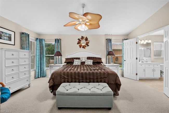 Bedroom with a ceiling fan, light carpet, and ensuite bathroom | Image 21