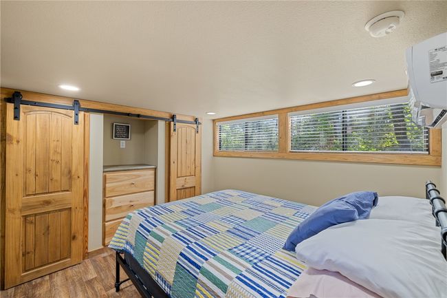 Bedroom with recessed lighting, a barn door, and wood finished floors | Image 9