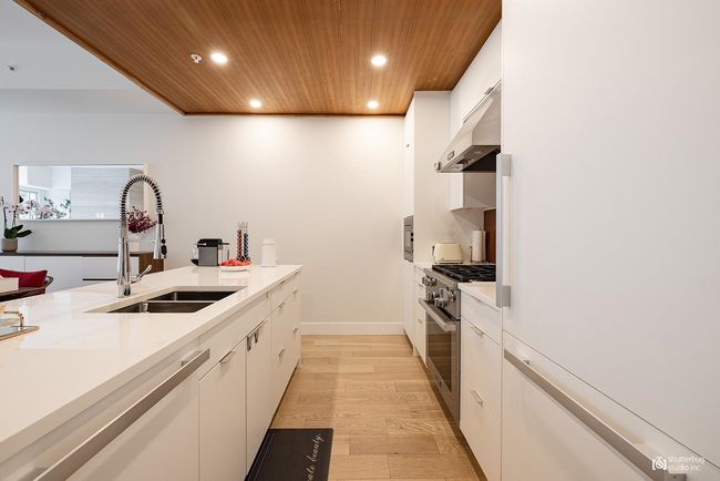 Kitchen with wooden ceiling, stainless steel stove, recessed lighting, under cabinet range hood, and a sink | Image 8