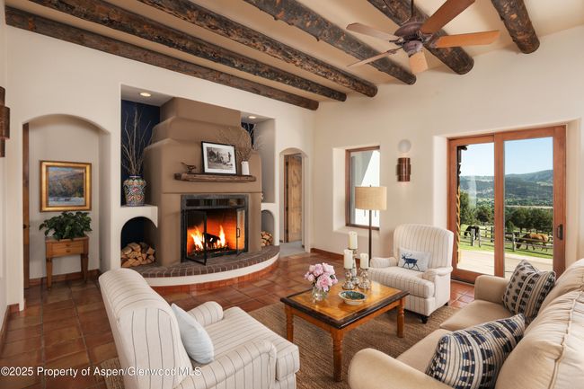A gas fireplace is the anchor of this great room with it's log accents and surrounding patio and deck. | Image 9