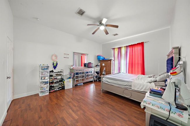 The primary suite is thoughtfully tucked away from the main living areas, offering enhanced privacy for homeowners. Oversized windows bring in natural light, while the high ceilings create an airy, open feel that elevates the space. | Image 16