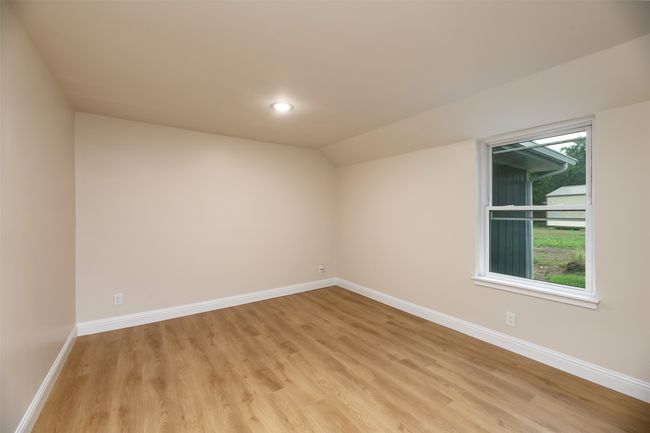 Empty room featuring light wood-style flooring, baseboards, vaulted ceiling, and recessed lighting | Image 16