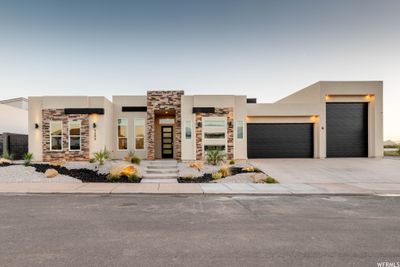 Pueblo-style house featuring a garage and central air condition unit | Image 1