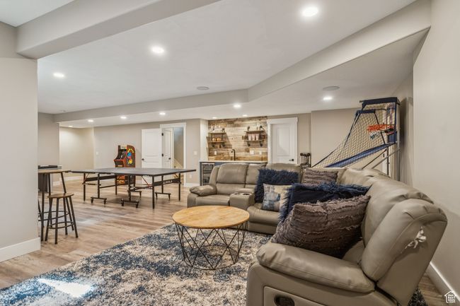 Living area featuring bar with sink, light wood finished floors, and recessed lighting | Image 54