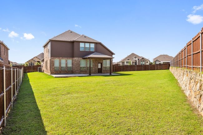 Back of property featuring brick siding, a patio area, a fenced backyard, and a shingled roof | Image 25