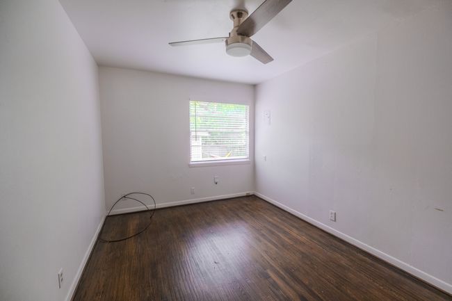 Empty room with a ceiling fan, baseboards, and wood finished floors | Image 8