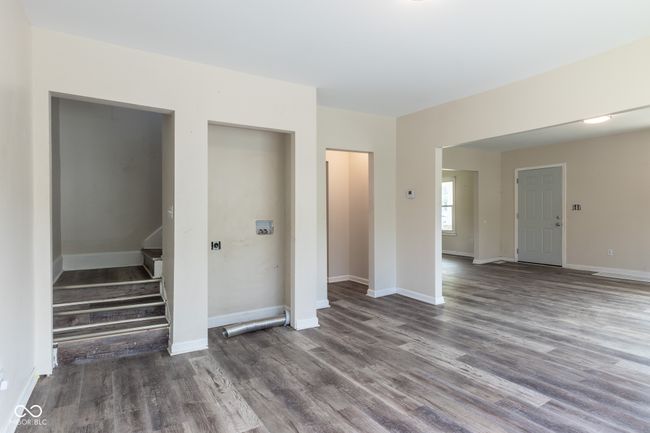unfurnished living room featuring baseboards, stairs, and wood finished floors | Image 17