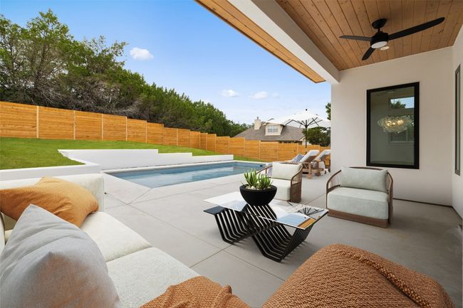 View of swimming pool featuring a fenced backyard, outdoor lounge area, a patio, and a ceiling fan | Image 25