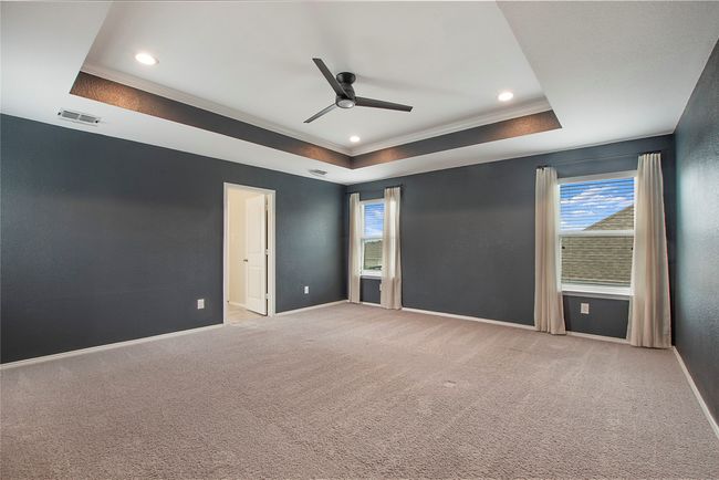 Spare room with a raised ceiling, ceiling fan, ornamental molding, healthy amount of natural light, and light colored carpet | Image 22