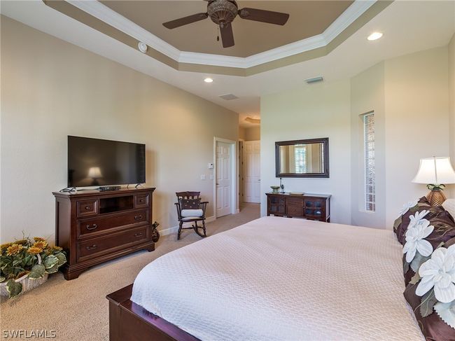 Carpeted bedroom featuring ceiling fan, a raised ceiling, and crown molding | Image 16