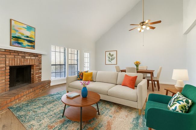 Virtually Staged Living area with high vaulted ceiling, wood finished floors, a fireplace, and a ceiling fan | Image 6