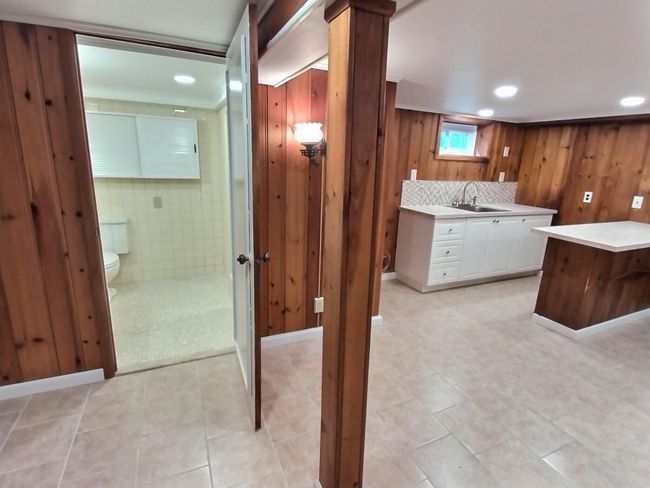 Bathroom featuring vanity, toilet, wooden walls, recessed lighting, and tile patterned flooring | Image 30