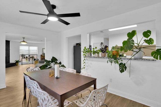 Dining space with light wood finished floors and a ceiling fan | Image 12