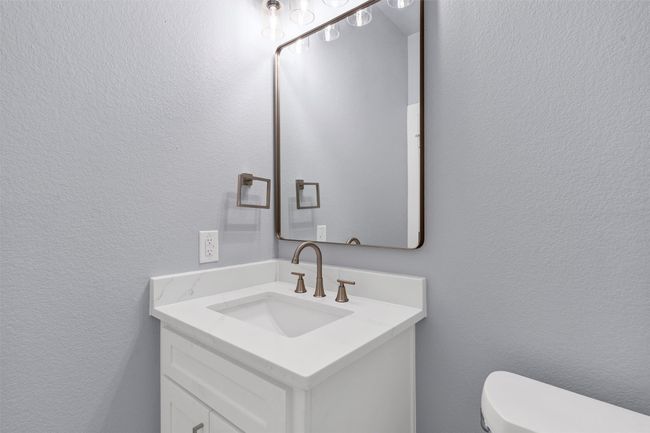 Half bath with vanity and a textured wall | Image 19