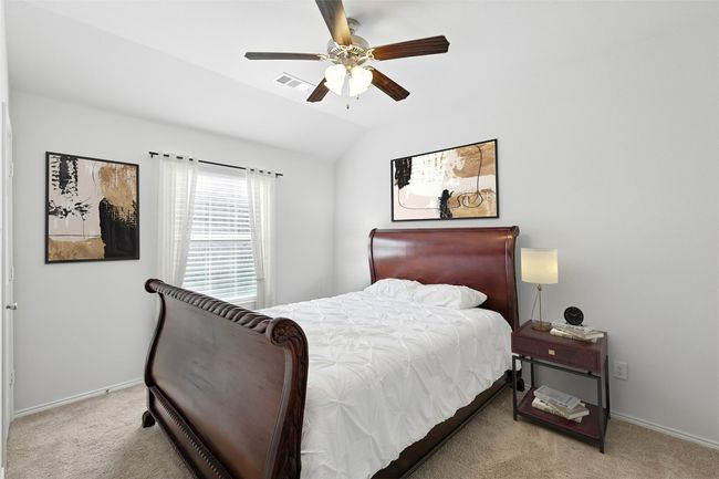 Bedroom featuring vaulted ceiling, visible vents, baseboards, and light carpet | Image 9