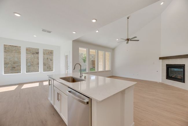 Kitchen featuring stainless steel dishwasher, open floor plan, light wood-style flooring, an island with sink, and recessed lighting | Image 5