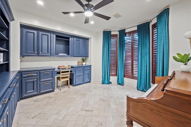 A second view of the study reveals a large bay window with floor-to-ceiling drapes, flooding the room with natural light—ideal for a peaceful workspace or music room. | Image 9