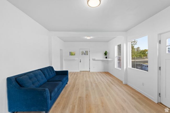 Living area with light wood-style flooring and baseboards | Image 4
