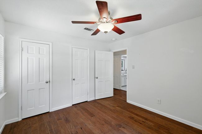 Unfurnished bedroom featuring dark wood-style floors and ceiling fan | Image 21