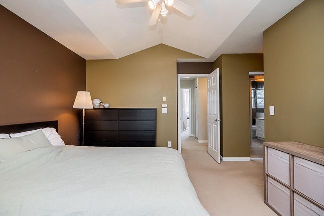 Bedroom with light colored carpet, baseboards, a ceiling fan, and lofted ceiling | Image 14