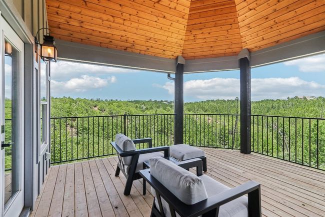 Wooden terrace featuring a gazebo and a wooded view | Image 37