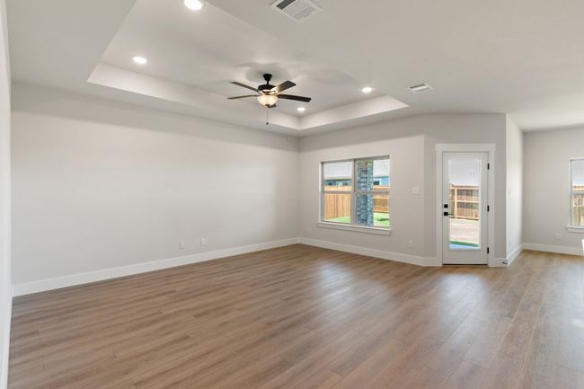 Spare room featuring a tray ceiling, light wood-type flooring, recessed lighting, and a ceiling fan | Image 9