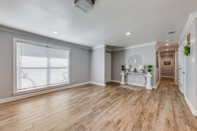 Unfurnished living room with light wood-type flooring, crown molding, and recessed lighting | Image 4