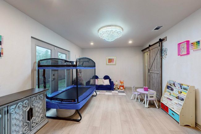 Currently used as a Playroom with light wood finished floors and a barn door | Image 16