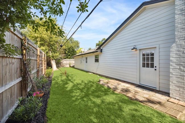 A view of the rear of the home, showcasing lush green space and landscaping. | Image 19
