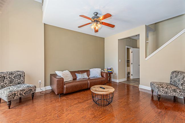 Living area featuring a ceiling fan and wood finished floors | Image 6