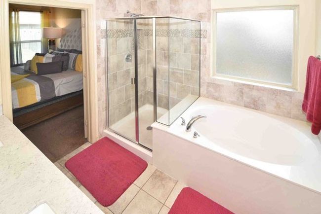 Bathroom featuring connected bathroom, a garden tub, a stall shower, and tile patterned floors | Image 19