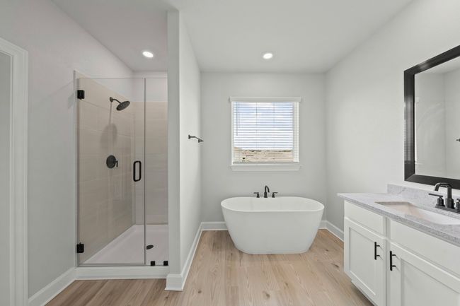 Master bathroom includes granite countertop, elongated mirror, and dual-vanity sinks. Relax in the large soaking tub or enjoy the spacious, standing shower. | Image 7