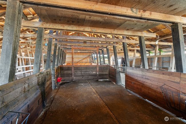 The barns are equipped with large stalls, perfect for accommodating larger animals, and versatile enough to serve as holding pens for groups of smaller animals. This flexible setup ensures the property can meet a variety of livestock or storage needs. | Image 31