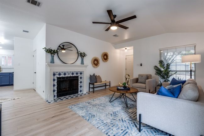 Living room with visible vents, ceiling fan, light wood-type flooring, vaulted ceiling, and a premium fireplace | Image 6