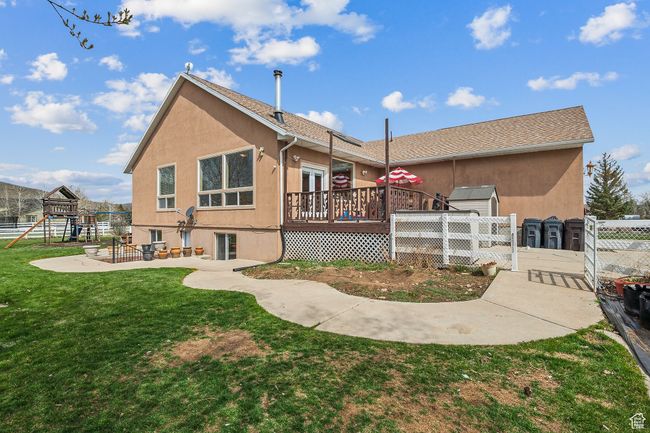 Rear view of house with stucco siding, a yard, fence, and a deck | Image 54