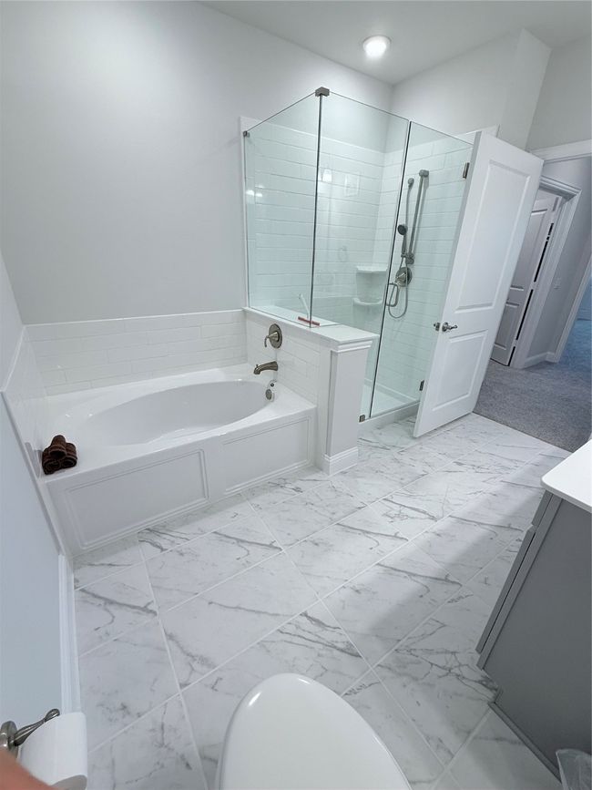 Primary in suite Bathroom featuring marble finish floors, double vanity, bathtub and walk in shower | Image 15