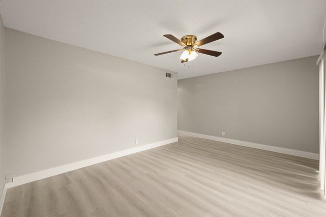 Spare room featuring ceiling fan and light wood-style flooring | Image 15